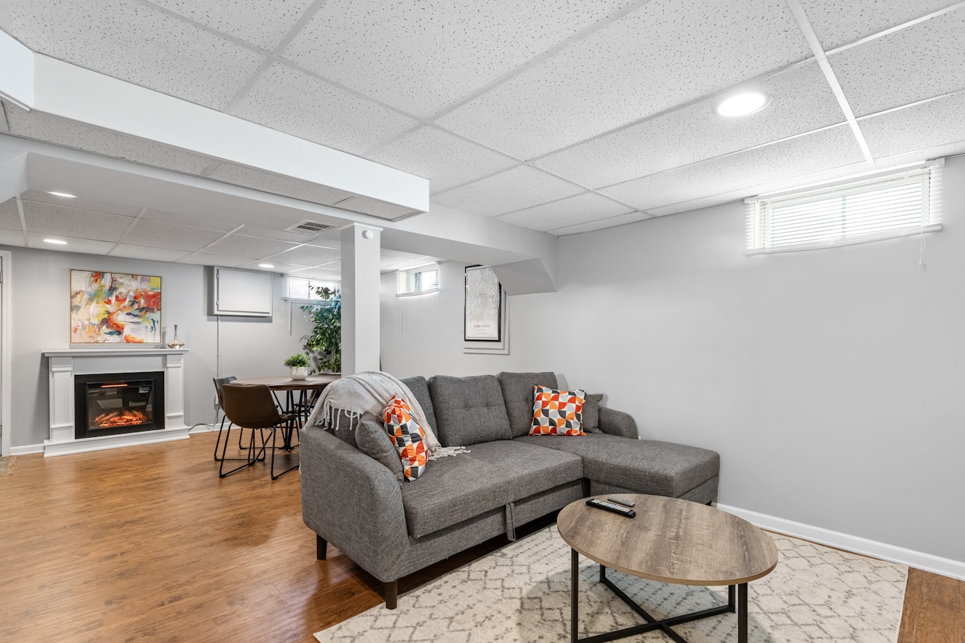 Finished basement living space with sectional sofa and fireplace